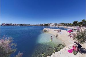 a group of people on a beach in the water at Apartman Dujmović in Split