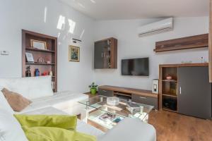 a living room with a white couch and a glass table at Valeria Apartment in Vabriga
