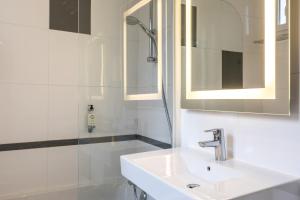 uma casa de banho branca com um lavatório e um espelho em Best Western Montcalm em Paris