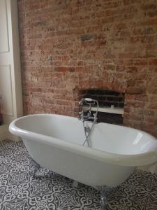 a white bath tub in front of a brick wall at The Crown Pub & Guesthouse in London
