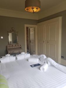 un grande letto con lenzuola bianche e asciugamani sopra di The Crown Pub & Guesthouse a Londra