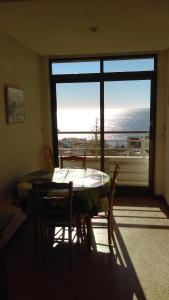 トレモリノスにあるApartamento centro Torremolinosの海の景色を望む客室で、テーブルと椅子が備わります。
