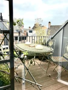 y balcón con mesa de patio y sillas. en Tempor'area Apartment, en Amberes