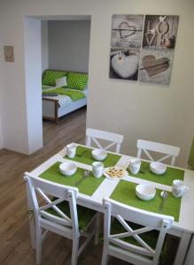 a white table and chairs with a green table cloth at Apartmán Staré Mesto in Banská Štiavnica