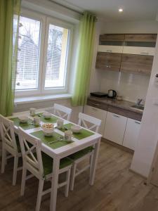 a kitchen with a white table and chairs in a room at Apartmán Staré Mesto in Banská Štiavnica