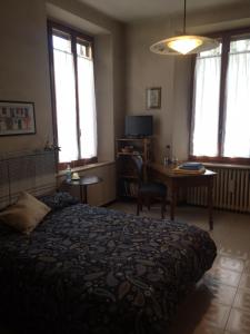 a bedroom with a bed and a table and windows at B&B Cittadella in Parma
