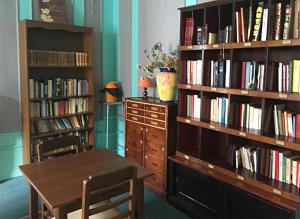 ブルボンヌ・レ・バンにあるRésidence PLEIN SOLEILのテーブルと本棚付きの部屋