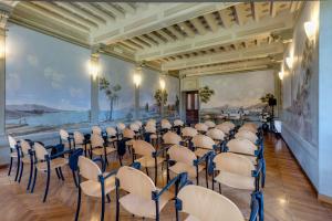 una habitación con una fila de sillas y una pared con pinturas en Villa La Stella, en Florencia