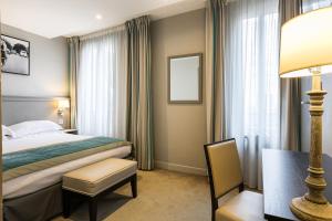 um quarto de hotel com uma cama e um candeeiro em Best Western Montcalm em Paris
