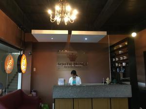 a woman standing behind a counter in a restaurant at South Prince Residences and Inn in Davao City