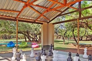 a chessboard in front of a pavilion with trees at Monateng Safari Lodge in Wallmannstal