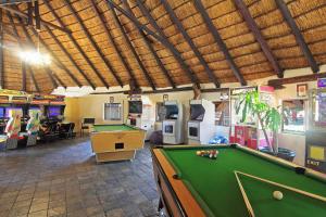 uma sala com uma mesa de bilhar e jogos de arcada em Monateng Safari Lodge em Wallmannstal