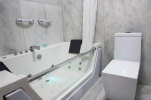 
a white bath tub sitting next to a white toilet at Luxury Inkari Hotel in Lima
