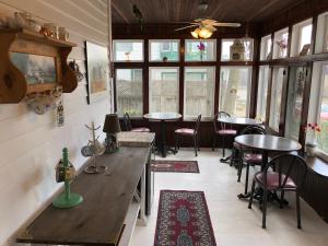 a restaurant with tables and chairs in a room with windows at Blue Gables Bed and Breakfast in Niagara Falls