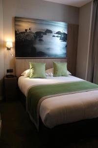 - un grand lit dans une chambre d'hôtel ornée d'une peinture murale dans l'établissement Le Mouton Blanc, au Mont-Saint-Michel