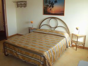 ペスキエーラ・デル・ガルダにあるAlbergo Marsariのベッドルームのベッド1台(ストライプ毛布付)