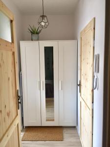 een hal met een witte kast met een spiegel bij Apartament la mar in Sopot
