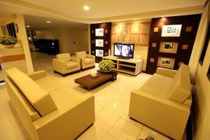 uma sala de estar com sofás e uma televisão de ecrã plano em San Manuel Praia Hotel em Aracaju