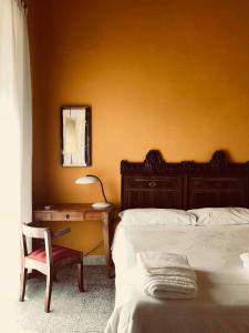 Schlafzimmer mit einem Bett, einem Schreibtisch und einem Stuhl in der Unterkunft Alcalà Living B&B in Catania