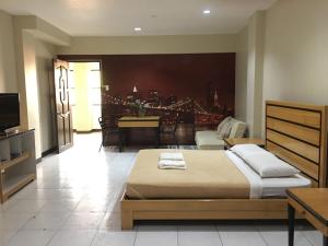 a bedroom with a bed and a living room at South Prince Residences and Inn in Davao City