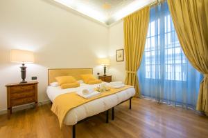 een slaapkamer met een groot bed met gele kussens bij Il Rigoletto in Como