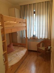 ティメンドルファー・シュトラントにあるZur kleinen Insel App.3の小さな客室で、二段ベッド1組、椅子が備わります。