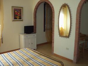 een slaapkamer met een bed en een spiegel aan de muur bij Albergo Marsari in Peschiera del Garda