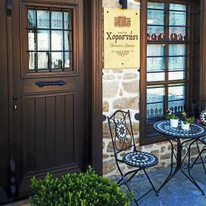 una mesa y sillas frente a una puerta en Chorostasi Mansion, en Arnaia