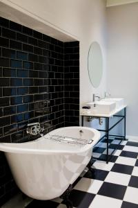 y baño con bañera blanca y lavamanos. en Elianthe Guesthouse, en Swellendam