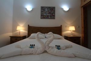 Dwa ręczniki w kształcie łabędzi leżą na łóżku w obiekcie Casa Branca da Vaquinha w mieście Angra do Heroísmo