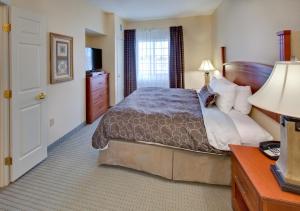 Habitación de hotel con cama y escritorio con lámpara. en Staybridge Suites Fargo, an IHG Hotel, en Fargo