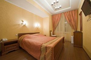 een slaapkamer met een bed en een televisie. bij Hotel on Dvoryanskaya in Kaloega