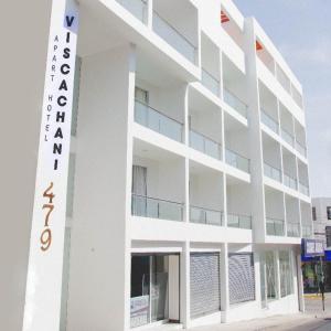 a white building with a sign on the side of it at Apart Hotel Viscachani in Arica
