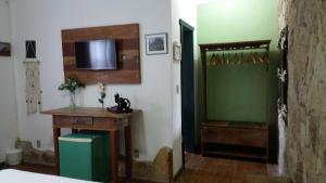 Cette chambre comprend un lit, une douche et une table. dans l'établissement Pousada Estação Tiradentes, à Tiradentes