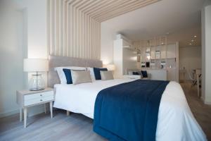 a bedroom with a large white bed with blue pillows at Almada Wine House in Porto