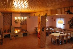 a dining room with a table and a fireplace at Pensiunea Alexandra in Vatra Moldoviţei