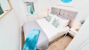 a bedroom with a white bed and a window at Snug - Tùr Sealladh Apartment in Helensburgh