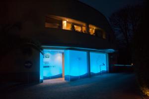un edificio iluminado de azul por la noche en Motel Paraiso, en Outeiro de Rei