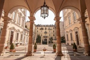 a large building with columns and a chandelier in a courtyard at Palazzo Graneri in Turin