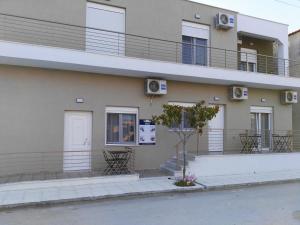 an apartment building with a balcony and a door at Sunny summer time in Nea Vrasna
