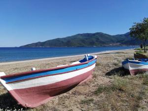 two boats sitting on a beach next to the water at Sunny summer time in Nea Vrasna