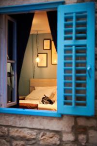 a bedroom with a bed with a blue window at Bubalus Boutique Rooms in Trogir