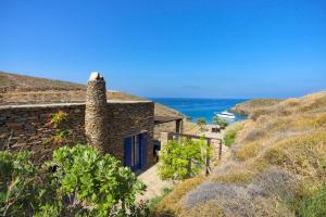 a stone house with a blue door on a hill at Amelia Beachfront Villa in Korissia