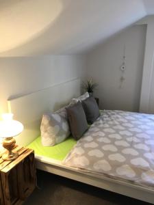 a bedroom with a bed with a lamp and pillows at Apartmentshaus Elbblick Zimmer "Bergblick" in Bad Schandau