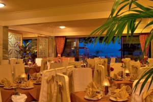 a restaurant with white tables and chairs with a view at JOHN & GEORGE in Tolo