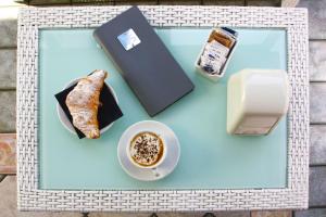 una mesa con una taza de café y una pastelería en Villa Serena, en Lido di Jesolo