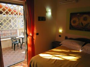 1 dormitorio con cama, mesa y ventana en Il Melograno en Nicotera Marina