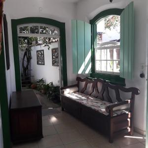 um quarto com um banco num quarto com uma janela em Pousada Sonho Meu em Paraty