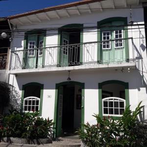 Edificio blanco y verde con balcón en Pousada Sonho Meu, en Paraty