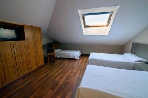 a bedroom with a bed, a desk and a window at Hotel el Palacio in Molinaseca